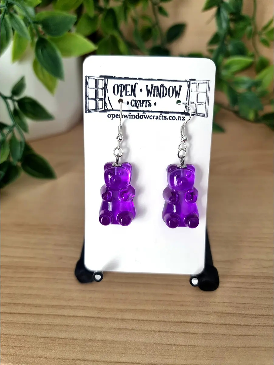 Purple gummy bear resin earrings dangle playfully.
