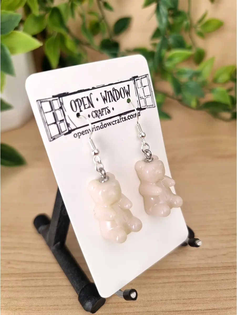 Translucent pastel resin gummy bear earrings dangle from silver hooks.