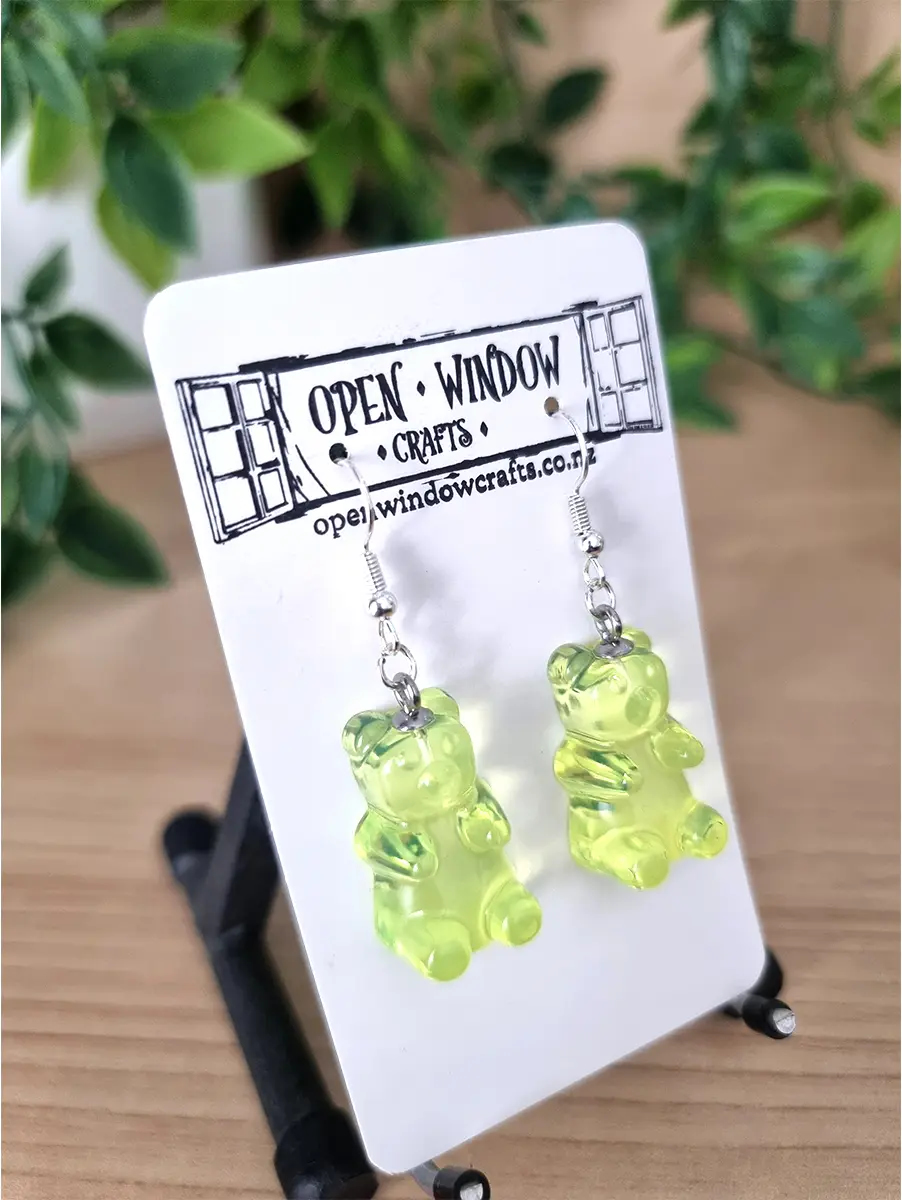 Lime green gummy bear earrings dangle from silver hooks.