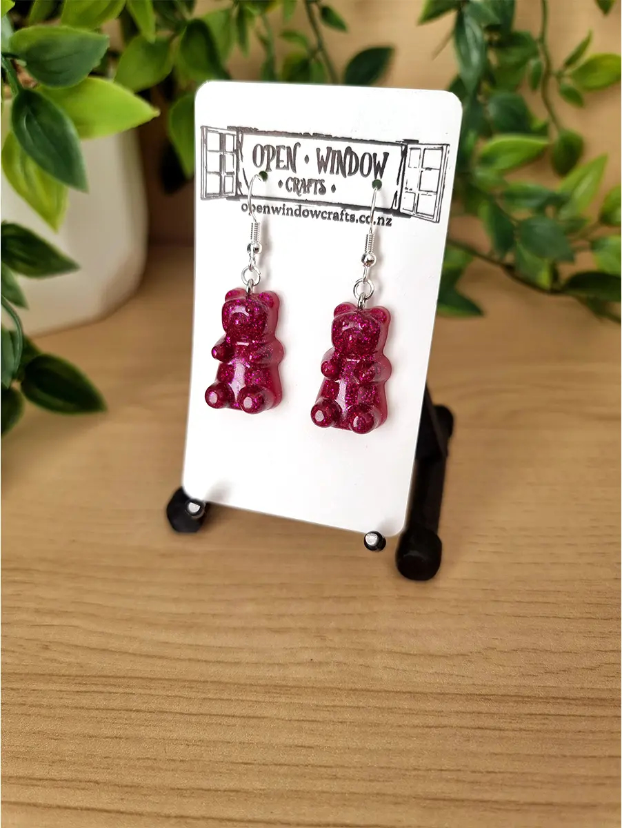 Raspberry gummy bear earrings showcase intricate glitter detail and a glossy finish.