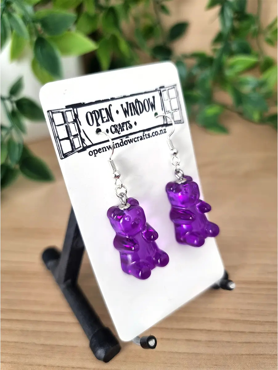 Purple gummy bear resin earrings dangle from silver hooks.