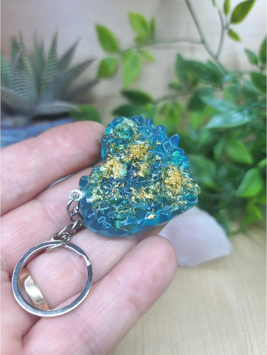 Blue and gold resin keychain mimics a natural geode formation with intricate crystal textures and shimmering gold flakes.